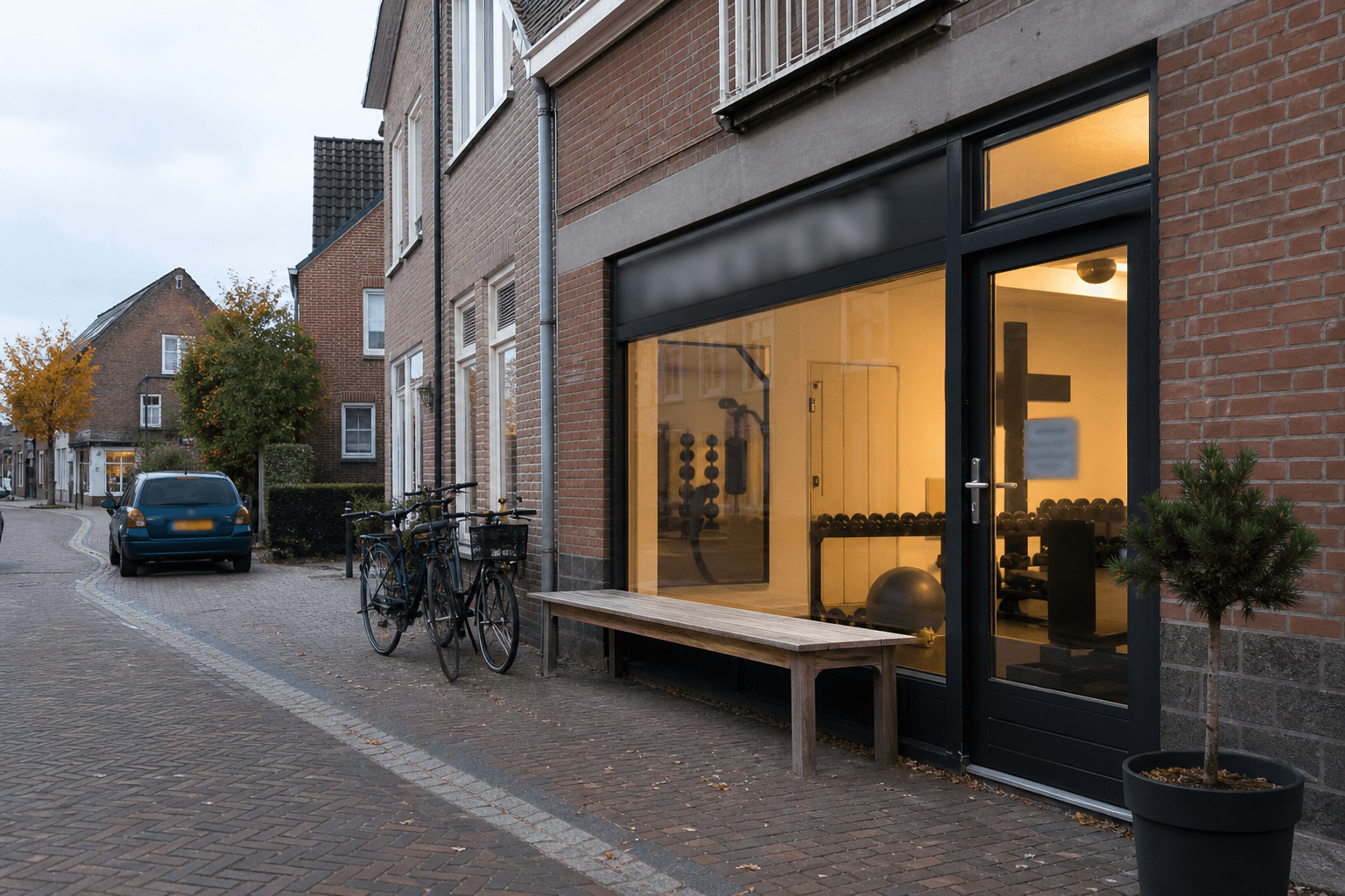 De ingang van de studio aan de Kerkstraat, met fietsen en een parkeerplaats ervoor